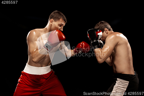 Image of Two professional boxer boxing on black background,