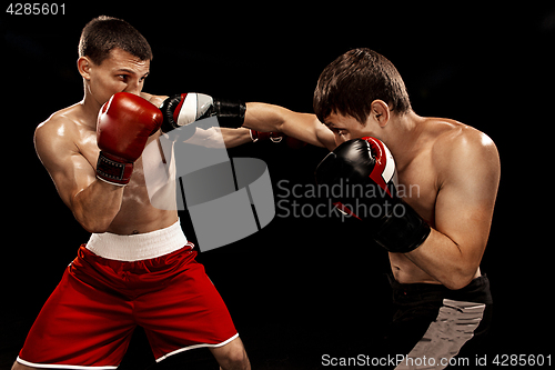 Image of Two professional boxer boxing on black background,