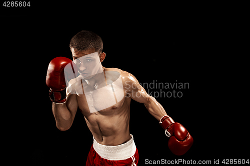 Image of Male boxer boxing with dramatic edgy lighting in a dark studio