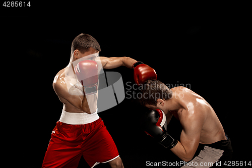 Image of Two professional boxer boxing on black background,