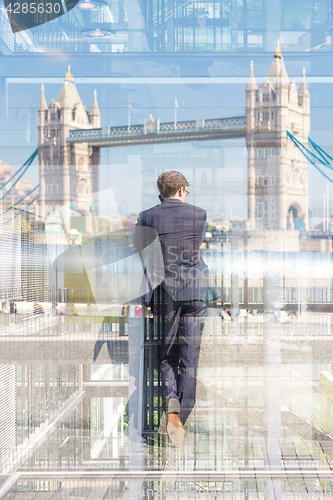 Image of British businessman talking on mobile phone in London city, UK.