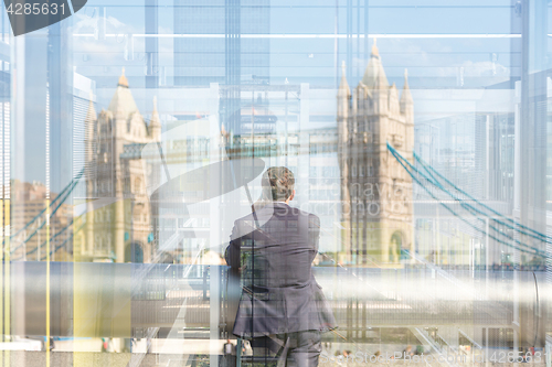 Image of British businessman talking on mobile phone in London city, UK.