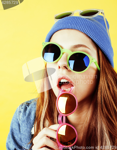 Image of lifestyle people concept: pretty young school teenage girl having fun happy smiling on yellow background 