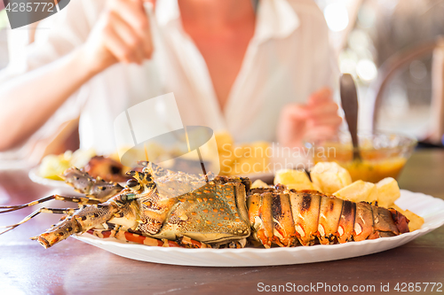 Image of Grilled lobster served with potatoes and coconut sauce.