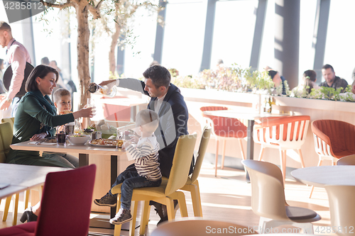 Image of Young parents enjoying lunch time with their children