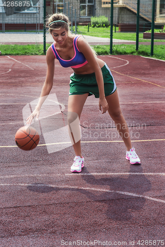 Image of woman in sportswear with basketball ball