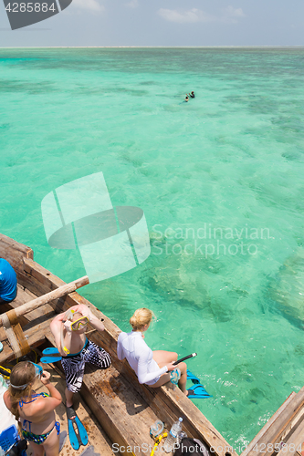 Image of Woman snorkeling in clear shallow sea of tropical lagoon with turquoise blue water.