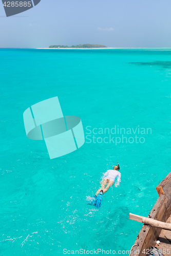 Image of Woman snorkeling in clear shallow sea of tropical lagoon with turquoise blue water.