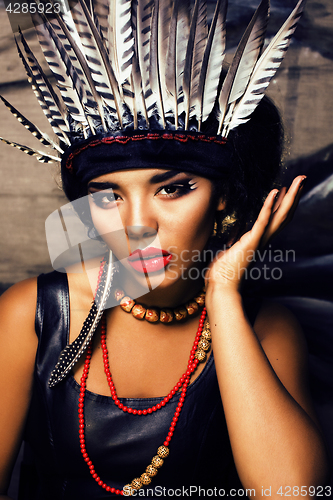 Image of young pretty woman with make up like red indian, futher in hair,