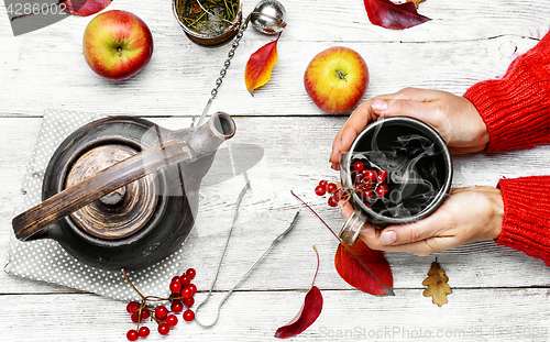 Image of Palm of your hand with cup of autumn tea