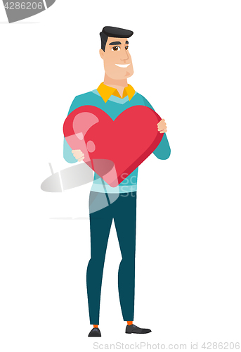 Image of Caucasian business man holding a big red heart.