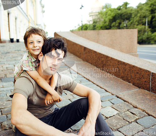 Image of Young father hipster and his little son outside. Talking, teachi