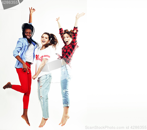 Image of three pretty young diverse nations teenage girl friends jumping happy smiling on white background, lifestyle people concept 