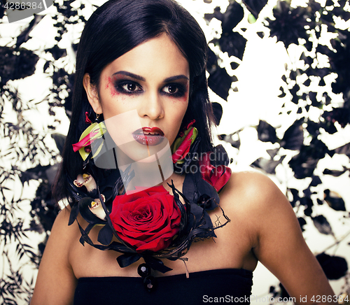 Image of pretty brunette woman with rose jewelry, black and red, bright m