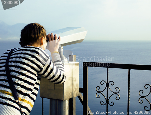 Image of young woman looking through telescope at sea viewpoint in Ataturk park