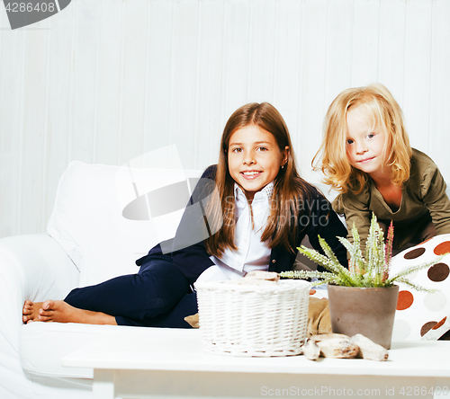 Image of two cute sisters at home playing, little girl in house interior 