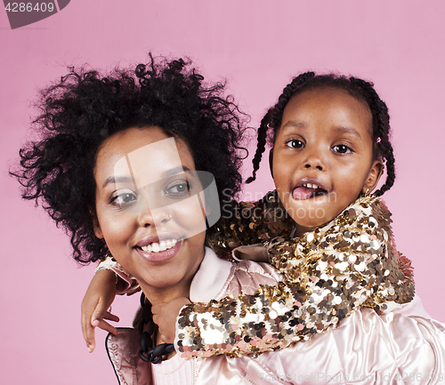 Image of young pretty african-american mother with little cute daughter hugging, happy smiling on pink background, lifestyle modern people concept 