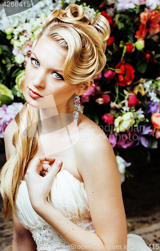 Image of beauty young blond woman bride alone in luxury vintage interior with a lot of flowers 