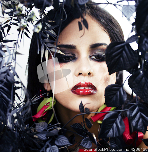 Image of pretty brunette woman with rose jewelry, black and red, bright m