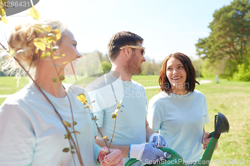 Image of group of volunteers with tree seedlings in park