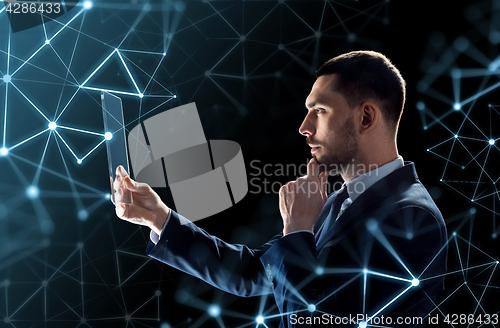 Image of businessman working with transparent tablet pc