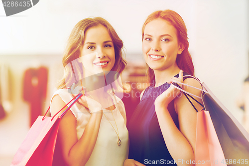 Image of happy women with shopping bags at clothing shop