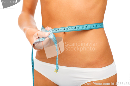 Image of close up of woman body with measure tape on waist