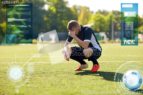 Image of sad soccer player with ball on football field