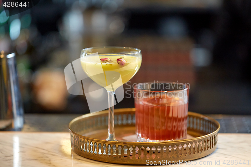 Image of tray with glasses of cocktails at bar