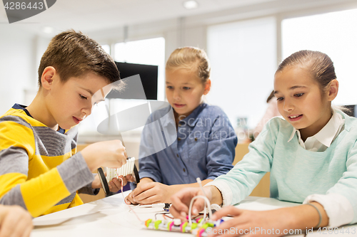 Image of happy children building robots at robotics school