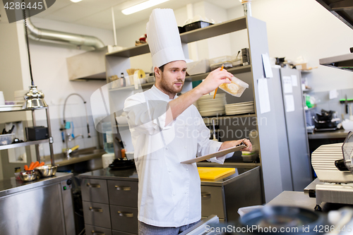 Image of chef with clipboard doing inventory at kitchen