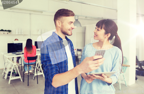 Image of couple with smartphone and tablet pc at office