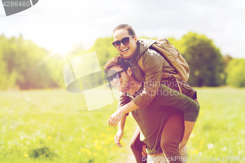 Image of happy couple with backpacks having fun outdoors