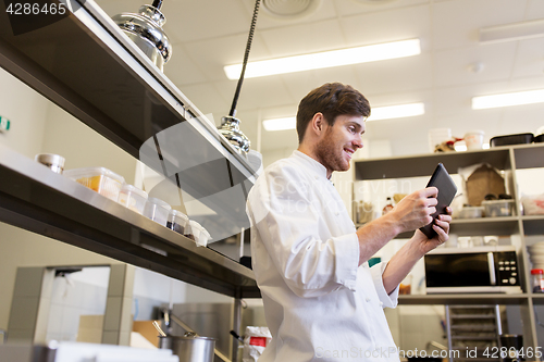Image of chef cook with tablet pc at restaurant kitchen