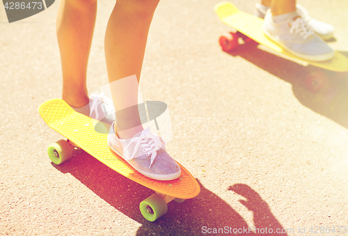 Image of close up of female feet riding short skateboard