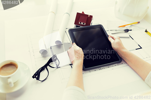 Image of close up of hand with blueprint and tablet pc