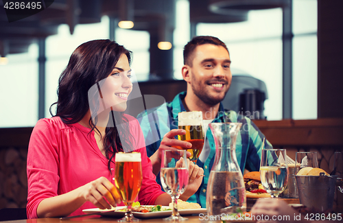 Image of friends dining and drinking beer at restaurant