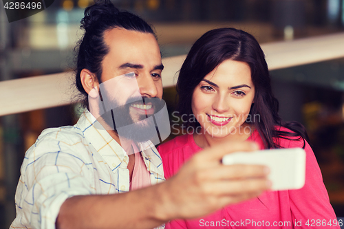 Image of couple taking selfie by smartphone at restaurant