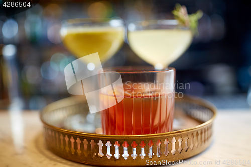 Image of tray with glasses of cocktails at bar