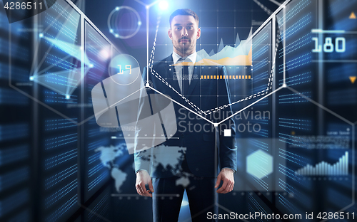 Image of businessman with charts on virtual screen