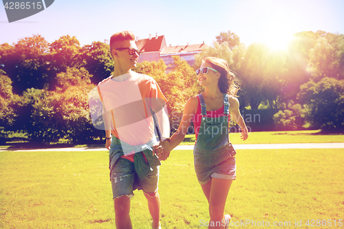Image of happy teenage couple walking at summer park