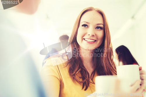 Image of happy creative team drinking coffee at office