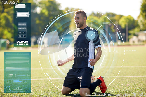 Image of happy soccer player with ball on football field