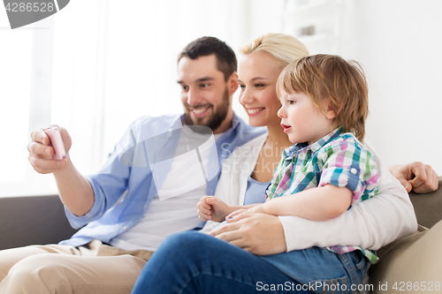 Image of happy family with smartphone at home