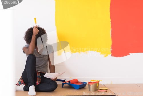 Image of back female painter sitting on floor