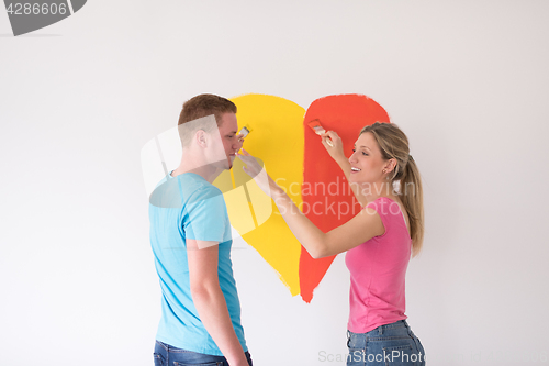 Image of couple are painting a heart on the wall