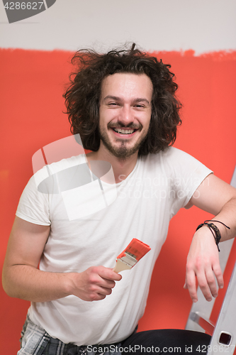 Image of man with funny hair over color background with brush