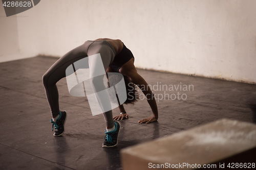 Image of black woman standing in bridge pose