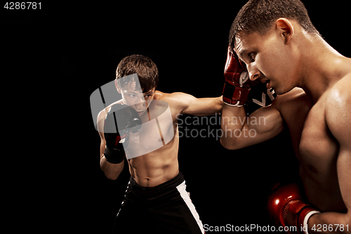 Image of Two professional boxer boxing on black background,