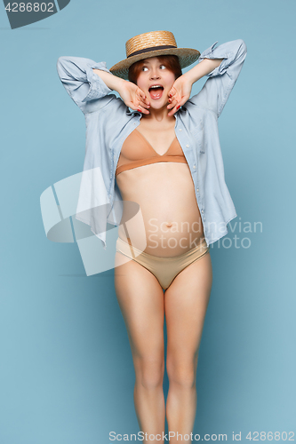 Image of Young beautiful pregnant woman standing on blue background